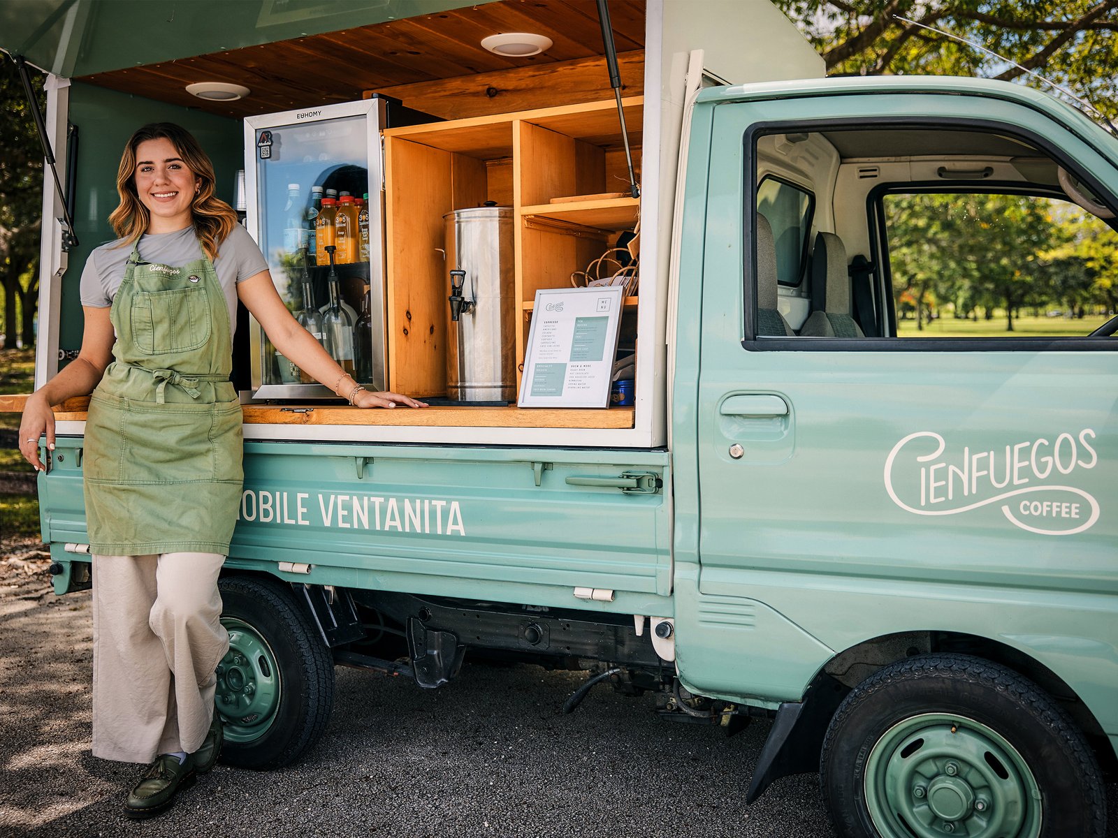 Small business owner standing beside her mobile coffee truck