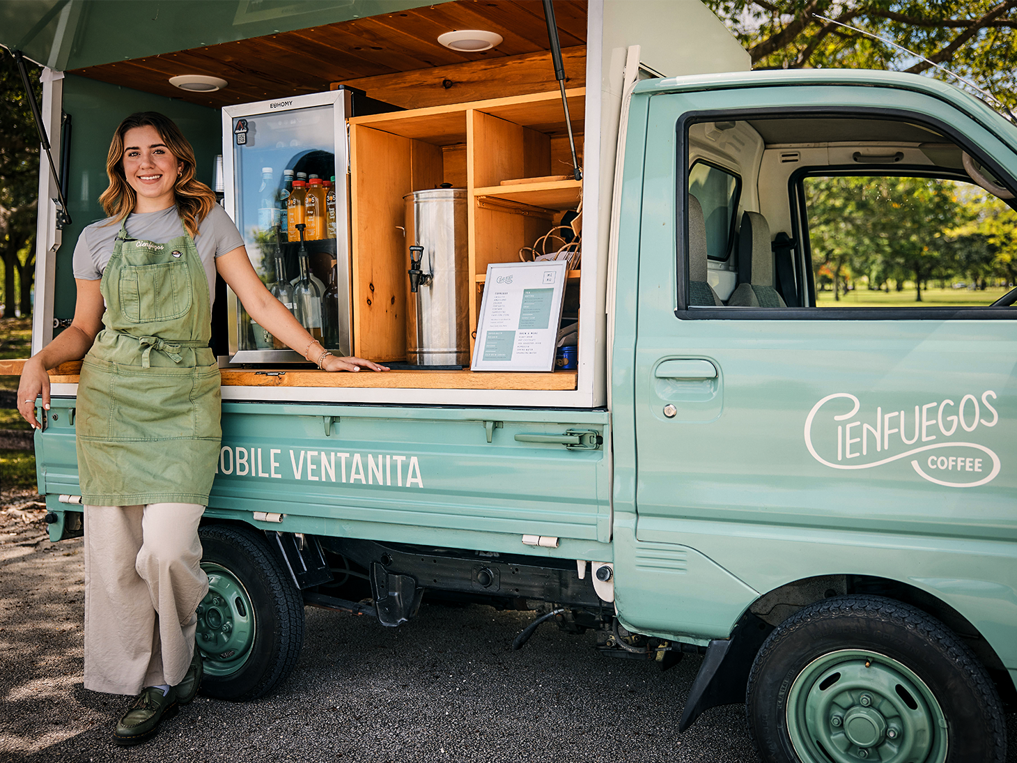 Small business owner standing beside her mobile coffee truck