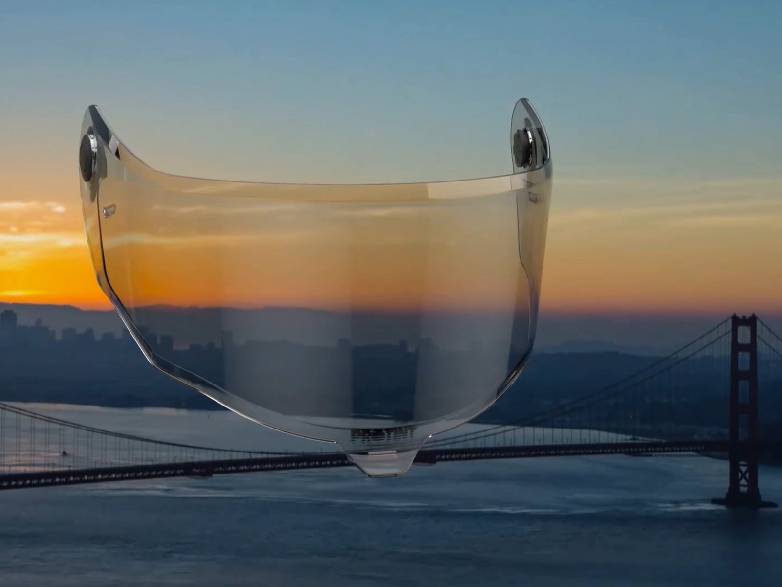 Transparent motorcycle helmet shield floating over Golden Gate Bridge sunset footage